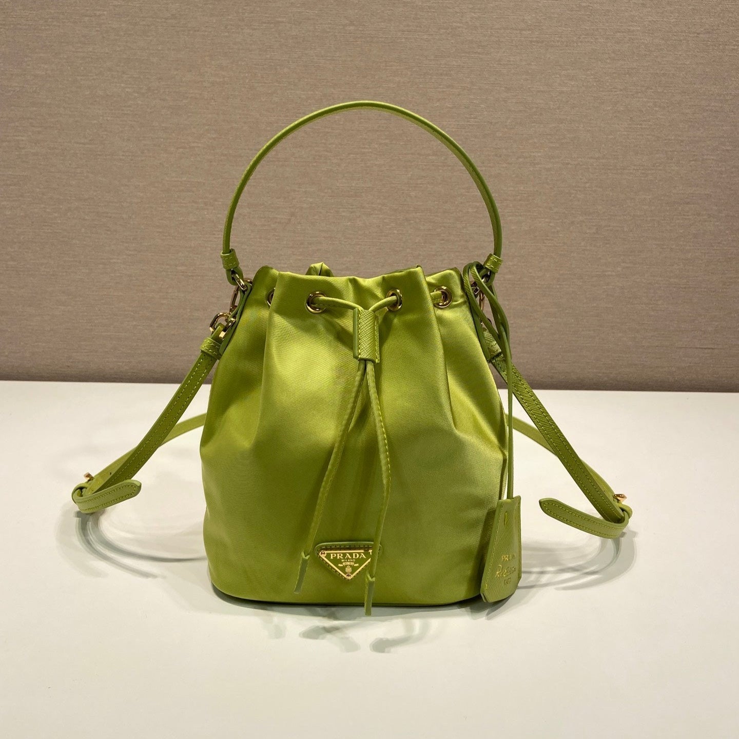 PRADA BUCKET BAG 19 IN APPLE GREEN RE-NYLON AND SAFFIANO LEATHER HANDLE